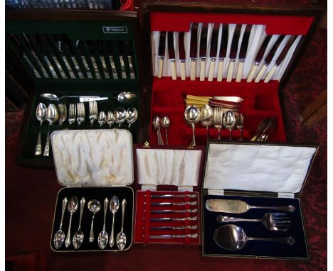A canteen containing a quantity of Oneida flatware with decorative pierced handles, an oak canteen containing further plated 