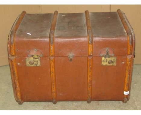 A vintage compressed fibre and timber lathe bound travelling trunk, with domed lid and brass fittings 