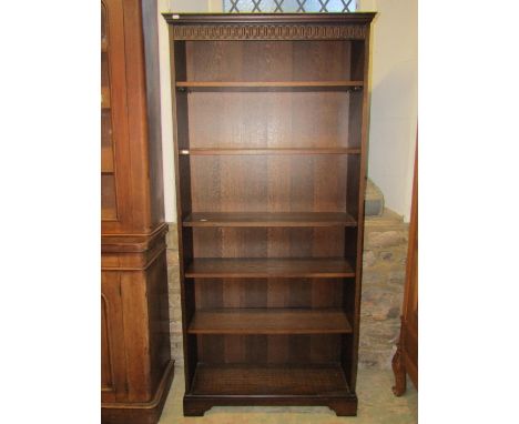 A pair of freestanding contempary dark stained oak freestanding open bookcases with moulded friezes over five adjustable shel