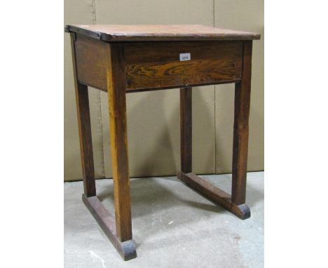 A vintage stained pine child's school desk with hinged box slope, ceramic inkwell and pen rest, raised on square cut and sled