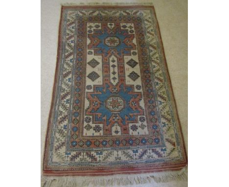 A Turkish wool carpet with blue and white field, the central medallions within geometric running borders, 185 cm x 110 cm 