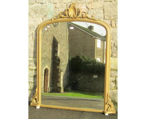 A Victorian overmantel mirror with gilt moulded arched frame, raised shell and scrolling acanthus pediment and corner bracket