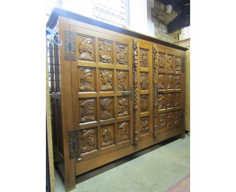 A medium oak side cupboard of continental origin enclosed by a pair of doors with portrait panels and exposed decorative fret