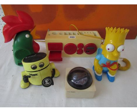 A collection of novelty plastic wares to include a Tomy Robot money box, a Bart Simpson telephone, a Kellogg's cornflakes rad