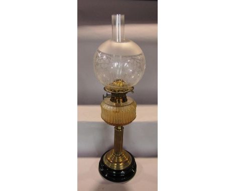 A Victorian brass oil lamp with reeded column and weighted ceramic foot, the font with fluted detail supporting a double wick