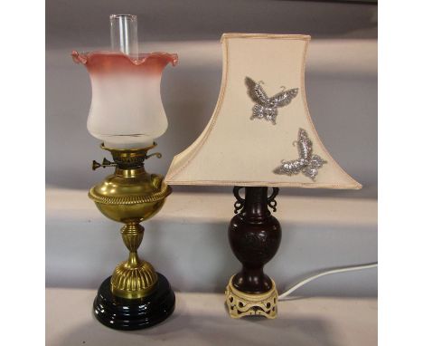 A Victorian brass oil lamp on a vase shaped column, with fluted base, with weighted ceramic foot and twin duplex burner, toge