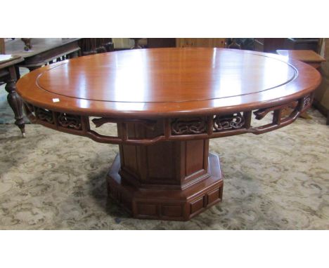 A good quality Chinese hardwood dining table, the circular top over a carved and pierced frieze raised on a central octagonal