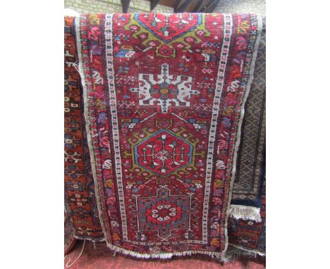 Persian style wool runner principally upon a red ground with repeating medallions within running borders, 160 x 60 cm approx 