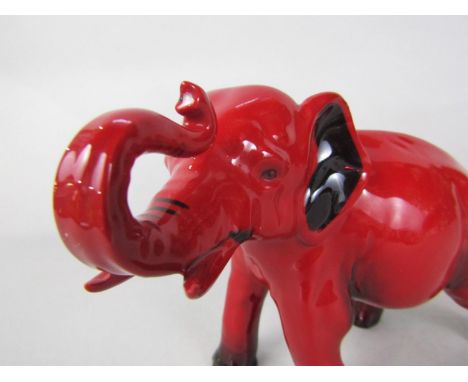 A Royal Doulton Flambé figure on an elephant with raised trunk 