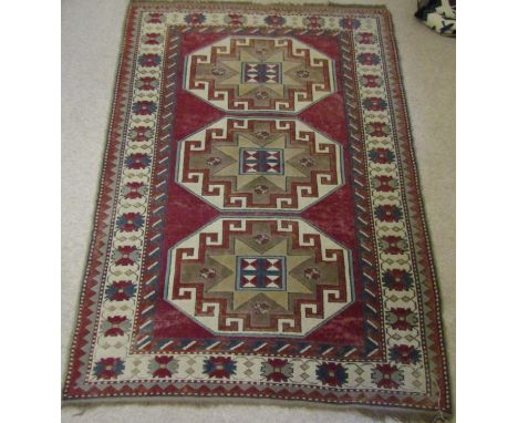 A Turkey wool carpet on a plum red field, the repeating geometric panels within further geometric running borders, 170 x 120 