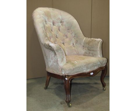 A mid-Victorian period drawing room chair with deep button back, serpentine seat and raised on a carved and moulded show wood