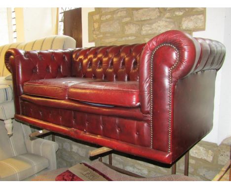 A traditional Victorian style Chesterfield sofa with deep buttoned back, upholstered in an ox red leather, 165 cm diameter 