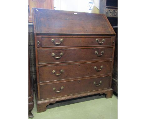 A Georgian oak bureau, the fall flap enclosing a fitted interior of small drawers, pigeon holes and central cupboard over fou