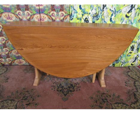 Ercol light elm drop leaf dining table on tapered bracket supports, 72cm high x 140cm extended 