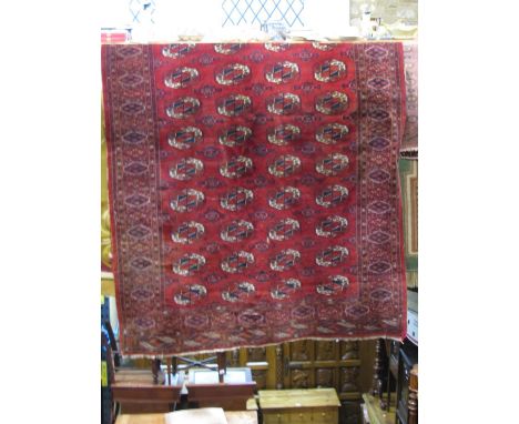 An Afghan red wool carpet with multi medallion panels within wide and narrow repeating geometric borders, 315 x 200 cm approx