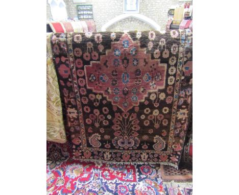 A Persian wool carpet with red field within foliated borders 200 x 135 cm approx, together with a further Persian wool rug, t