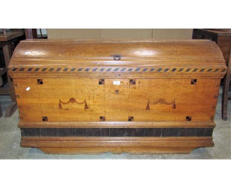 An 18th century oak domed topped trunk with exposed dovetail and pegged construction, inlaid detail and heavy drop carrying h