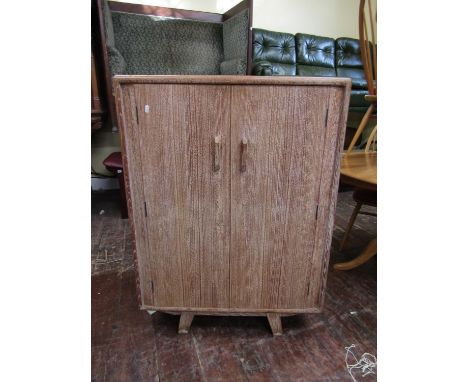Heal's style limed oak cupboard, fitted with two hinged doors upon splayed bracket feet, 117cm high x 84cm wide 