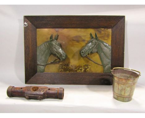 An early 20th century framed panel in relief showing two mares with metallic finish, within a wedge shaped oak frame, silver 