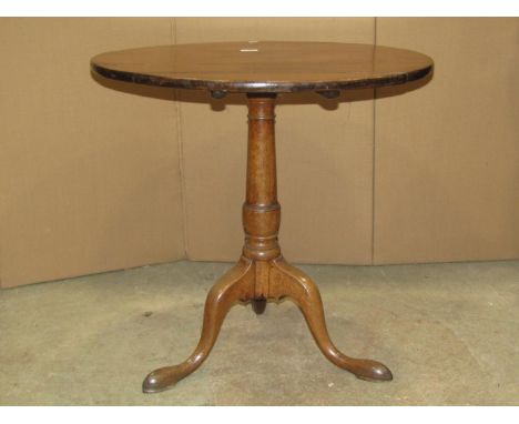 A Georgian oak snap top table, the top raised on a gun barrel pillar and tripod base, 72cm diameter approx 
