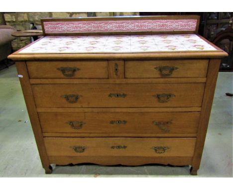A late 19th century oak chest of three long and two short drawers, the top inset with original art nouveau ceramic tiles of o