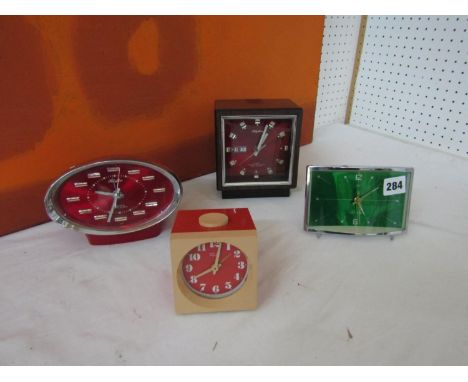 A collection of retro alarm clocks to include a Rhythm four jewel transition bell clock with day date aperture, a further Rhy