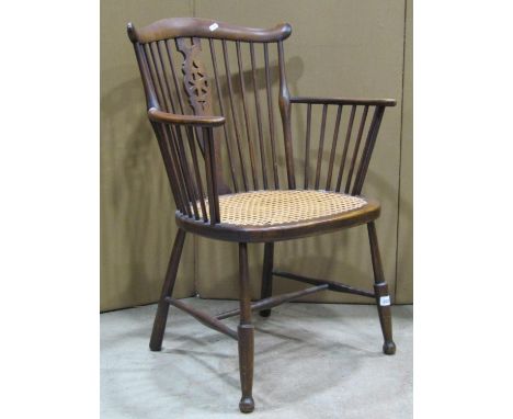 An Edwardian Windsor stick back elbow chair with wheel back splat, cane work seat on turned supports and stretchers 