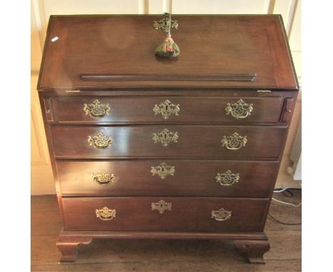 A Georgian mahogany bureau, the fall flap enclosing a fitted interior of small drawers, pigeon holes and central cupboard wit