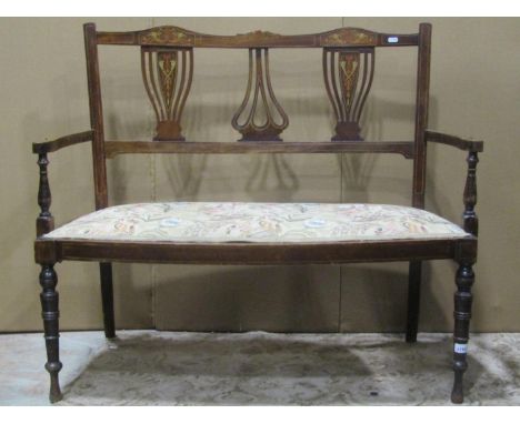 An inlaid Edwardian lightweight two seat parlour sofa, with pierced vase shaped splats over an upholstered seat, raised on ri