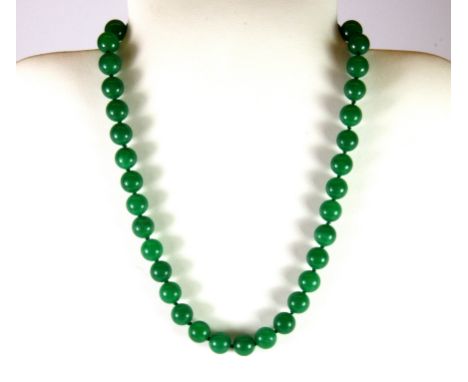 A jade bead necklace on a white metal clasp.