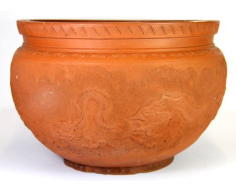 A large mid 20th century Chinese Yixing terracotta planter with incised and stipple decoration of dragons among clouds. W. 42