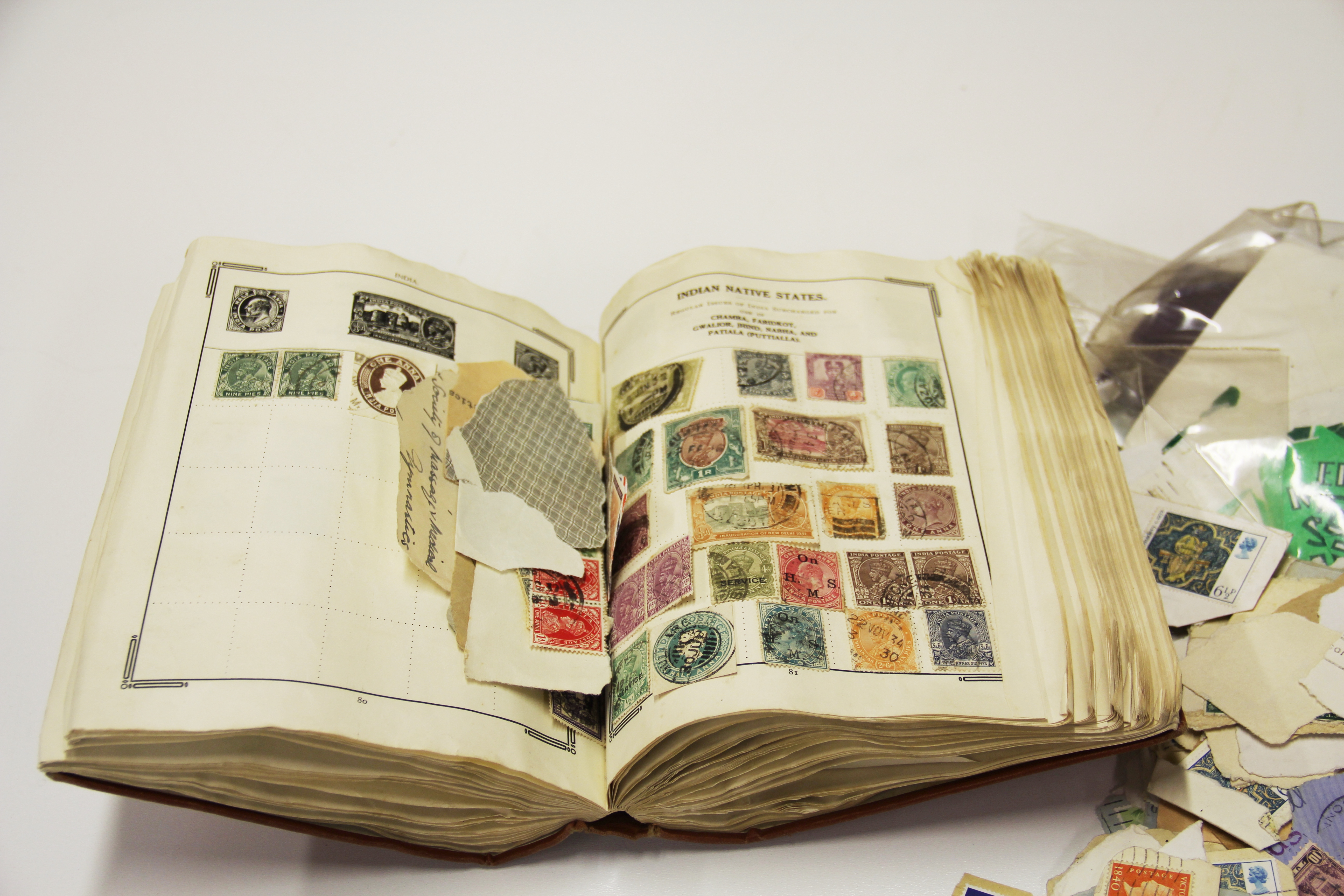 A vintage stamp album and loose stamps.