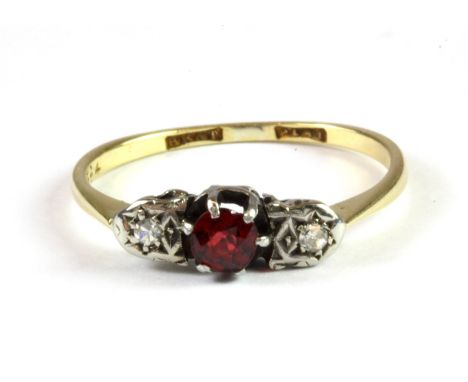 An 18ct yellow gold and platinum ring set with a red spinel flanked by diamonds, (R.5).