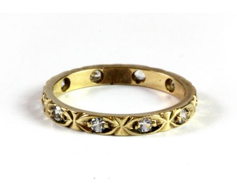 A 9ct yellow gold (stamped 9ct) white spinel set fill eternity ring, (M.5).