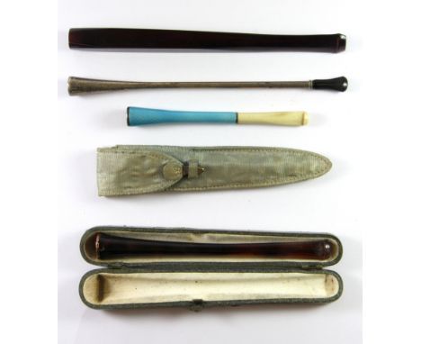Four early cigarette holders, one with guilloche enamel in a silk case.