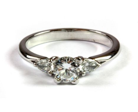 A lovely 14ct white gold (stamped 585) ring set with a brilliant cut diamond flanked by two pear shaped diamonds, (L.5).