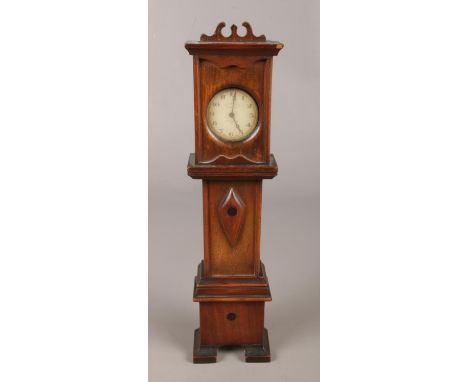 An Inventic white metal pocket watch, housed in a miniature mahogany longcase clock stand.  