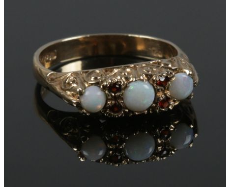 A 9ct gold opal and garnet ring. Hallmarks for London 1975. Size Q. 3.66g.  