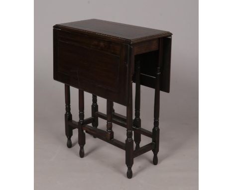 A dark hardwood drop leaf and gate leg table. H: 73cm, W: 86cm fully open.  