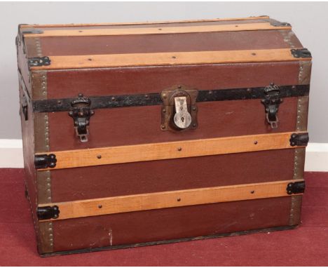 A large wooden slat domed trunk. Comprising of two carry handles and metal brackets. H: 51cm, W: 69cm, D: 43cm.  