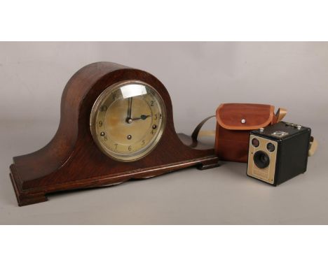 A vintage oak cased Napoleon hat mantle clock, along with a cased Kodak six-20 Brownie D camera.  