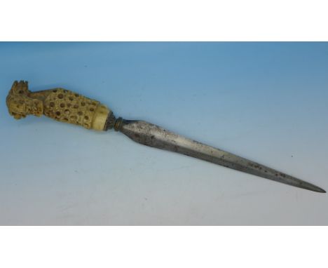 An Indonesian or Malayan dagger with carved handle