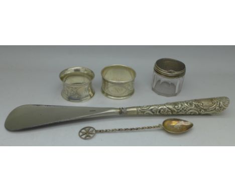 Two silver napkin rings, silver handled shoe horn, silver topped jar and a silver spoon