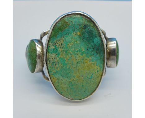 A large white metal and turquoise bangle