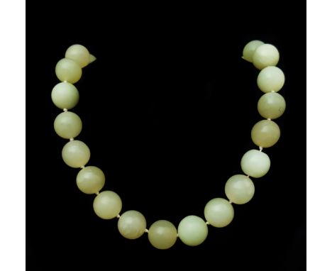 A Chinese slightly graduated row of 39 12mm to 15mm pale whitish green coloured jade beads to a silver gilt clasp, purchased 