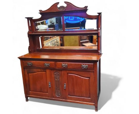 An Arts &amp; Crafts walnut mirror backed sideboard, swan neck pediment super structure above shaped bevelled mirror plates f