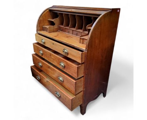 A George III mahogany roll top bureau, tambour front revealing pigeon holes and drawer lined interior above four long graduat