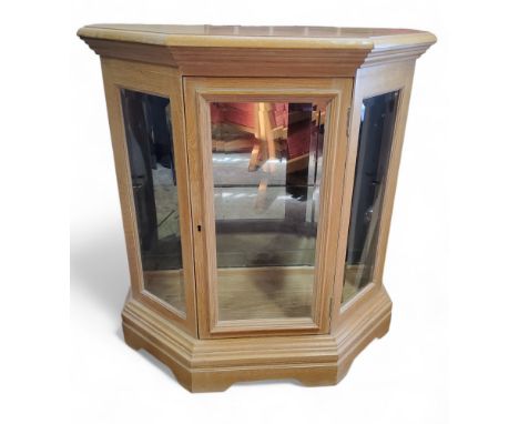 A contemporary limed canted display cabinet, plinth base, bracket feet, 78cm high, 72cm wide 