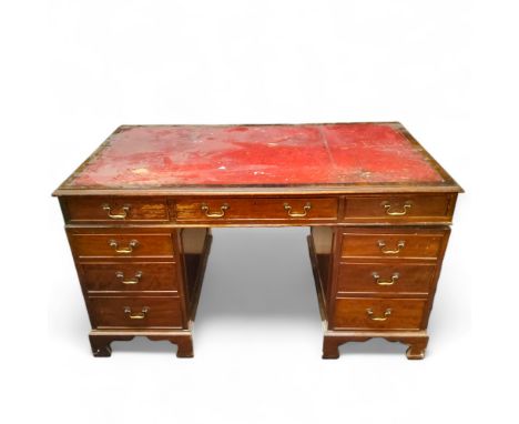 A 20th century twin pedestal desk, tooled leather inlaid writing surface above one long flanked by two short cockbeaded drawe