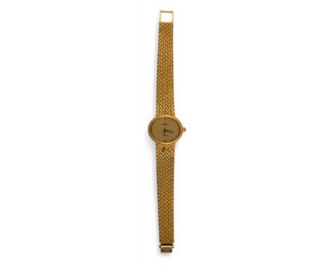Baume et Mercier, Geneva c. 1970 A ladies 18 carat yellow gold wristwatch. The oval shaped dial with plaited bezel on a sligh
